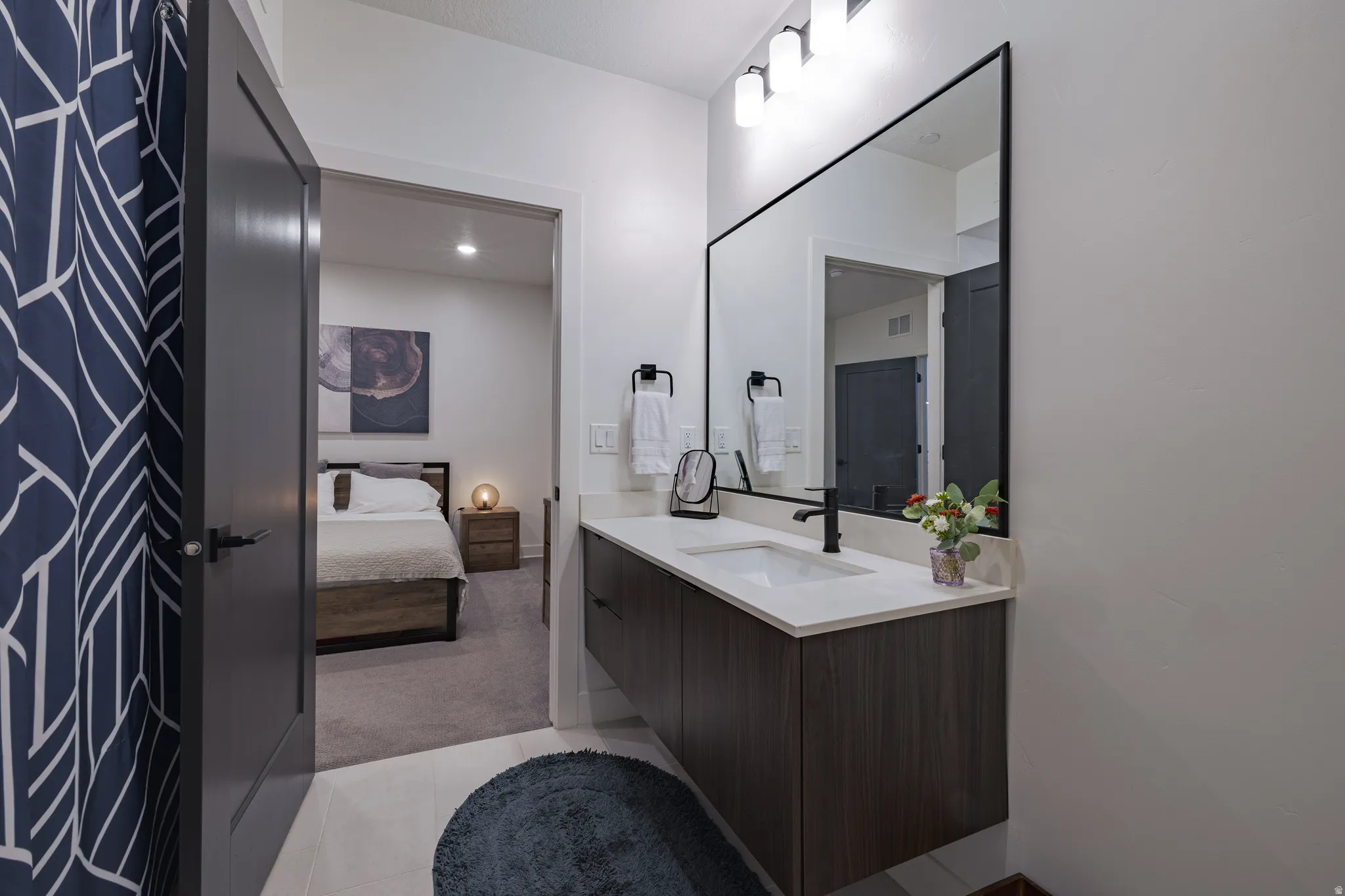 Floating vanity with a quartz countertop, rectangular sink, and matte black faucet