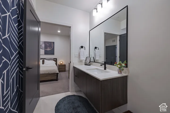 Floating vanity with a quartz countertop, rectangular sink, and matte black faucet