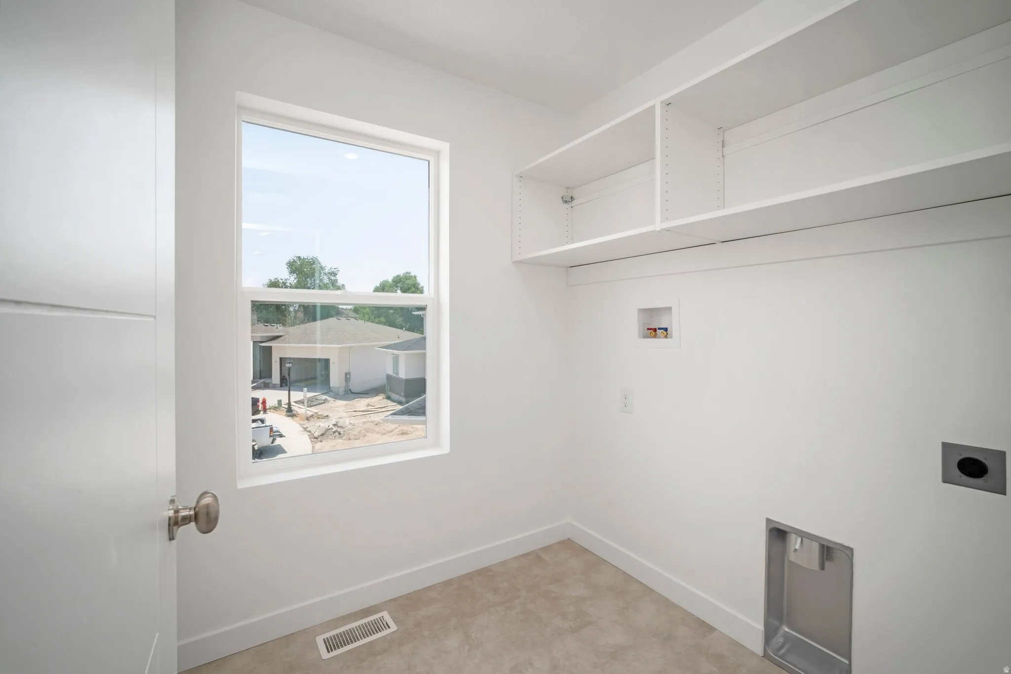 Built-in shelving, natural light, contemporary door, and utility hookups