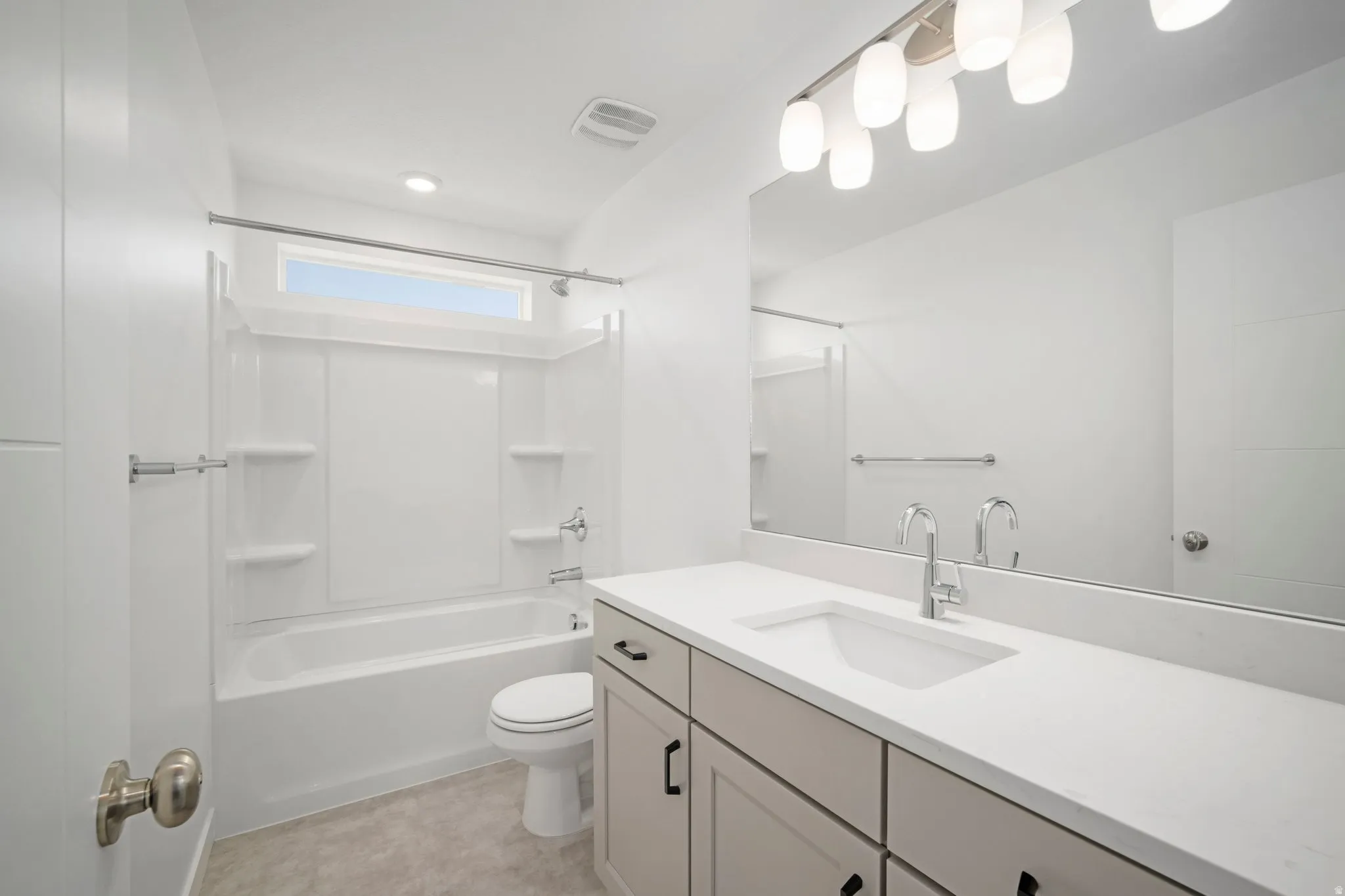 White vanity with a single basin sink, white countertop, and brushed nickel faucet