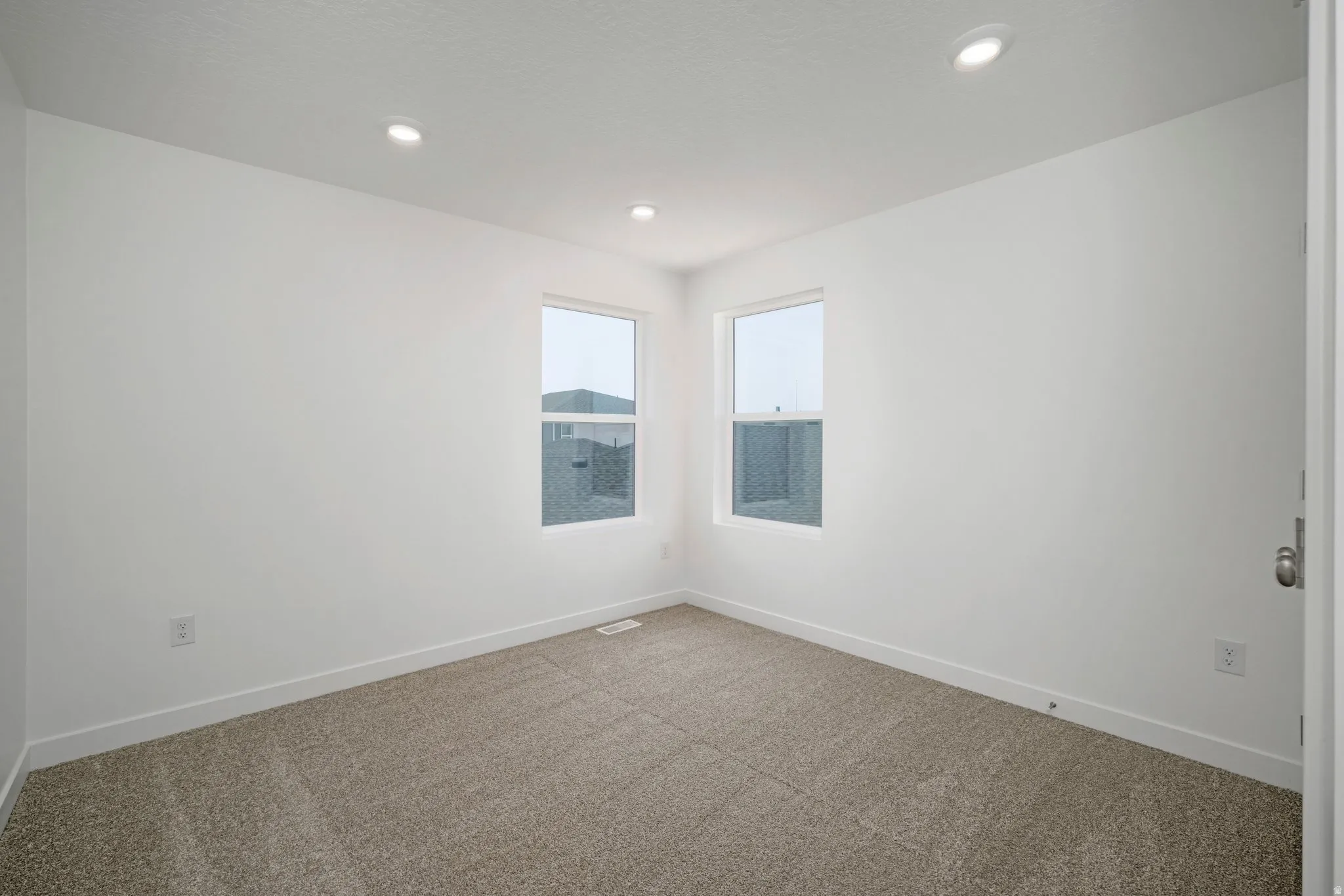 Recessed lighting, carpet flooring, and white interior walls