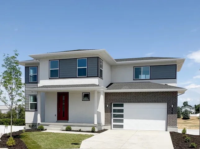 Modern exterior with a contrasting red entry door, gray siding accents, and a white garage door featuring frosted glass panels