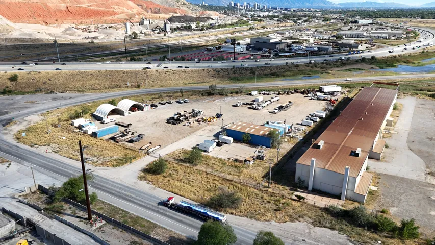 Large industrial building with an extensive adjacent lot, surrounded by paved roads and highway access