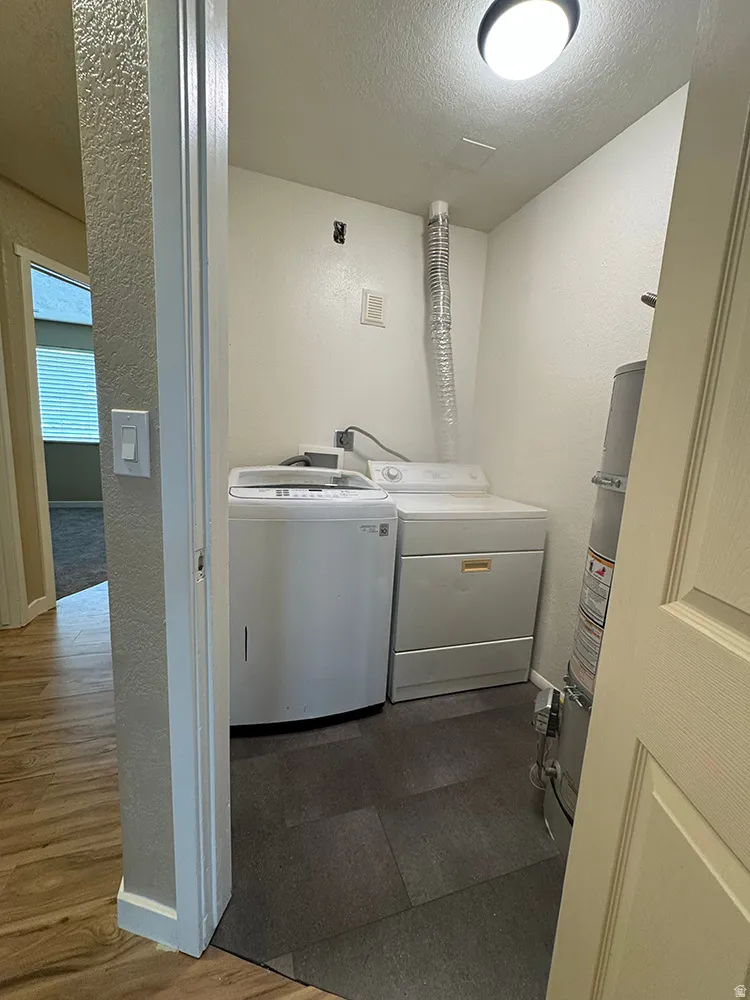 Dedicated laundry area featuring dark tile flooring and overhead lighting