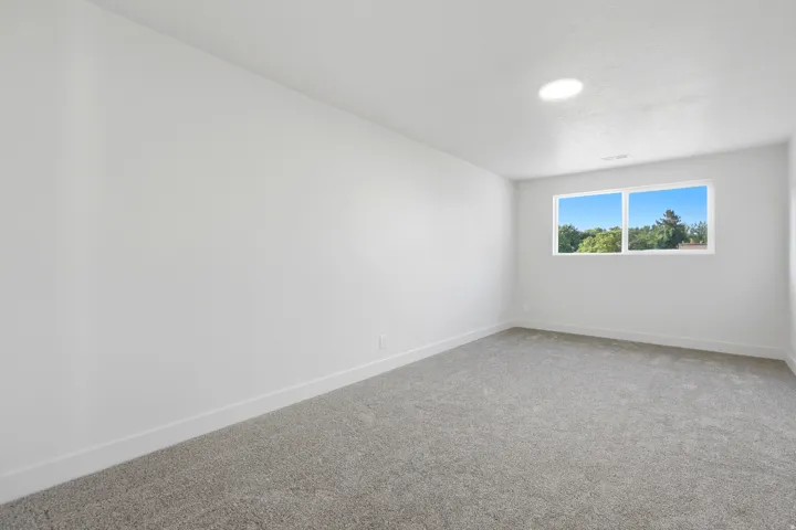 Recessed lighting with a window and neutral-toned carpet