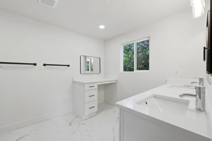 Dual vanity with integrated sinks, white cabinetry, and polished chrome faucets