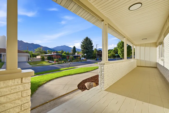 Spacious front porch featuring a painted brick facade and ceiling-mounted lighting