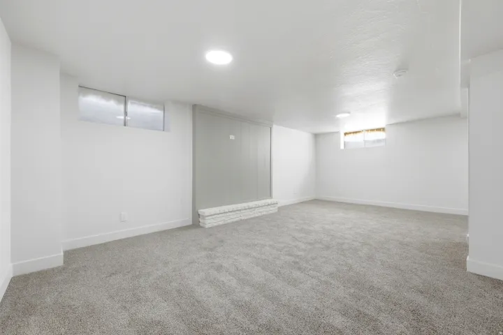 Spacious room featuring plush carpeting, flush-mount lighting, and white baseboards