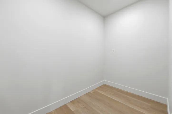 Recessed lighting, wood-finish flooring, and white walls