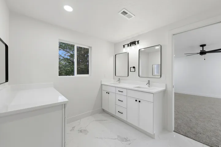 Dual vanity with undermount sinks, quartz countertops, and matte black hardware