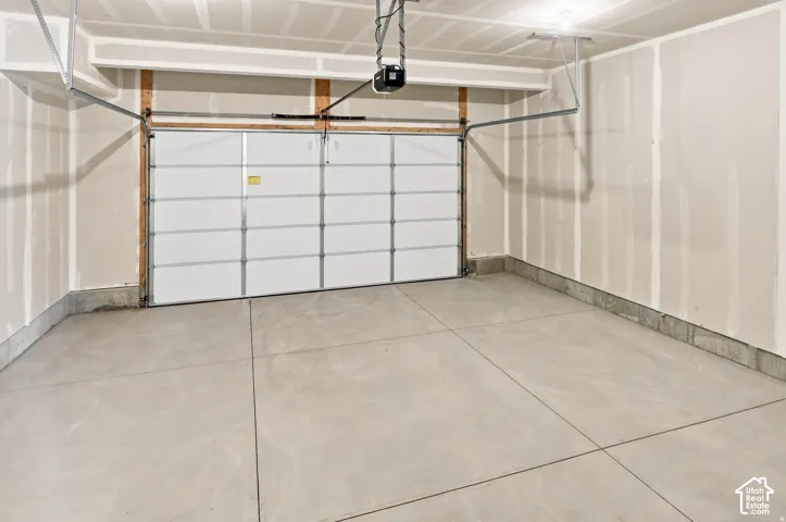 Attached overhead garage door with a concrete floor and neutral-toned walls