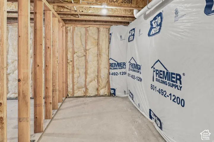Unfinished basement space with exposed wooden framing and concrete flooring