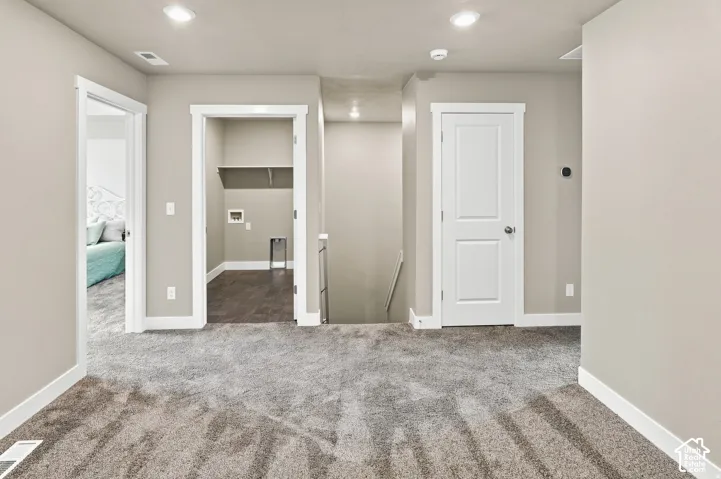 Plush carpeting, recessed lighting, and a dedicated laundry area with dark wood-finish flooring