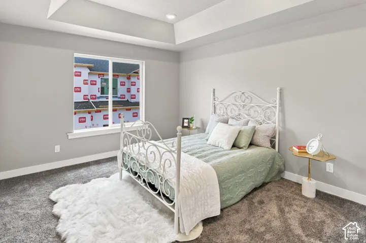 Tray ceiling with recessed lighting, light gray wall finishes, gray carpet, and a white framed window