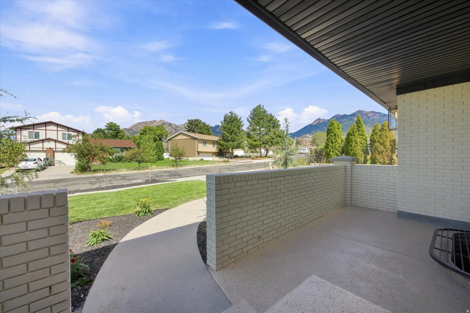 Expansive covered patio with light-colored brick walls and a concrete surface