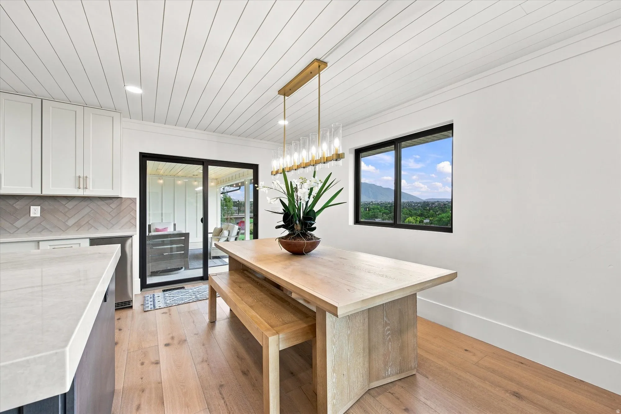 Recessed lighting, wood-finish flooring, white shiplap ceiling, sliding glass door, and a built-in window