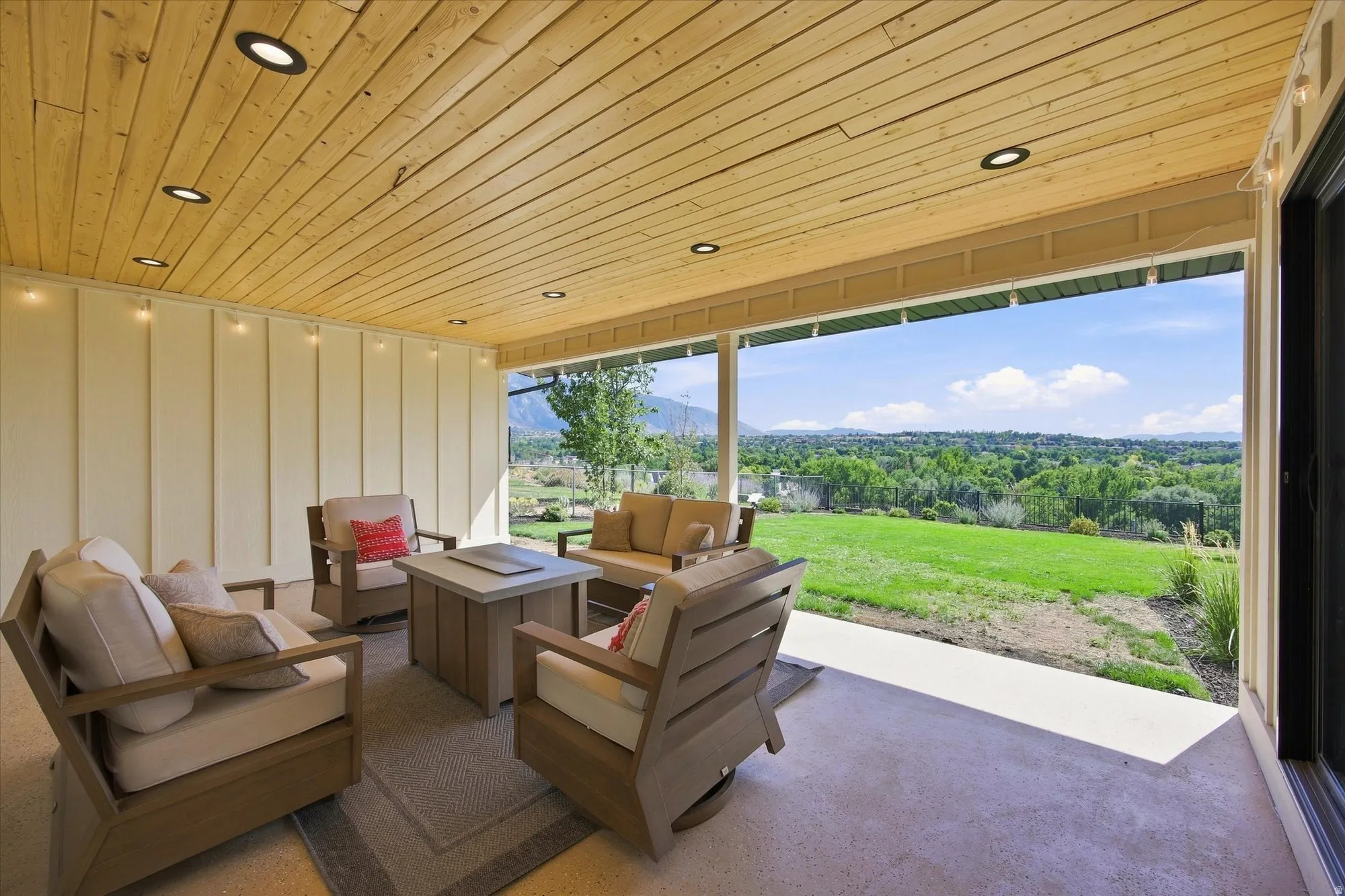 Covered patio featuring a wood-paneled ceiling with recessed lighting, board and batten siding, and a concrete patio floor