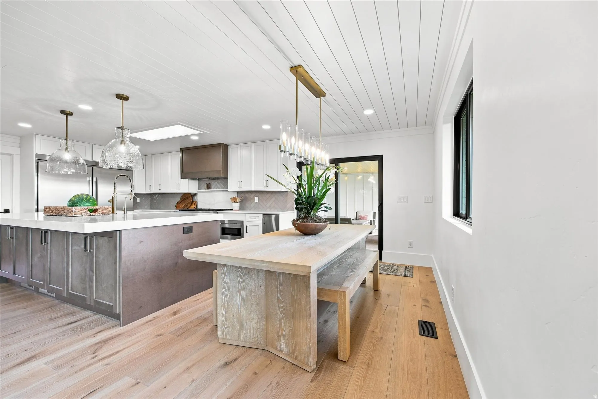 Gourmet kitchen with white cabinetry, a large center island, and wood-finish flooring