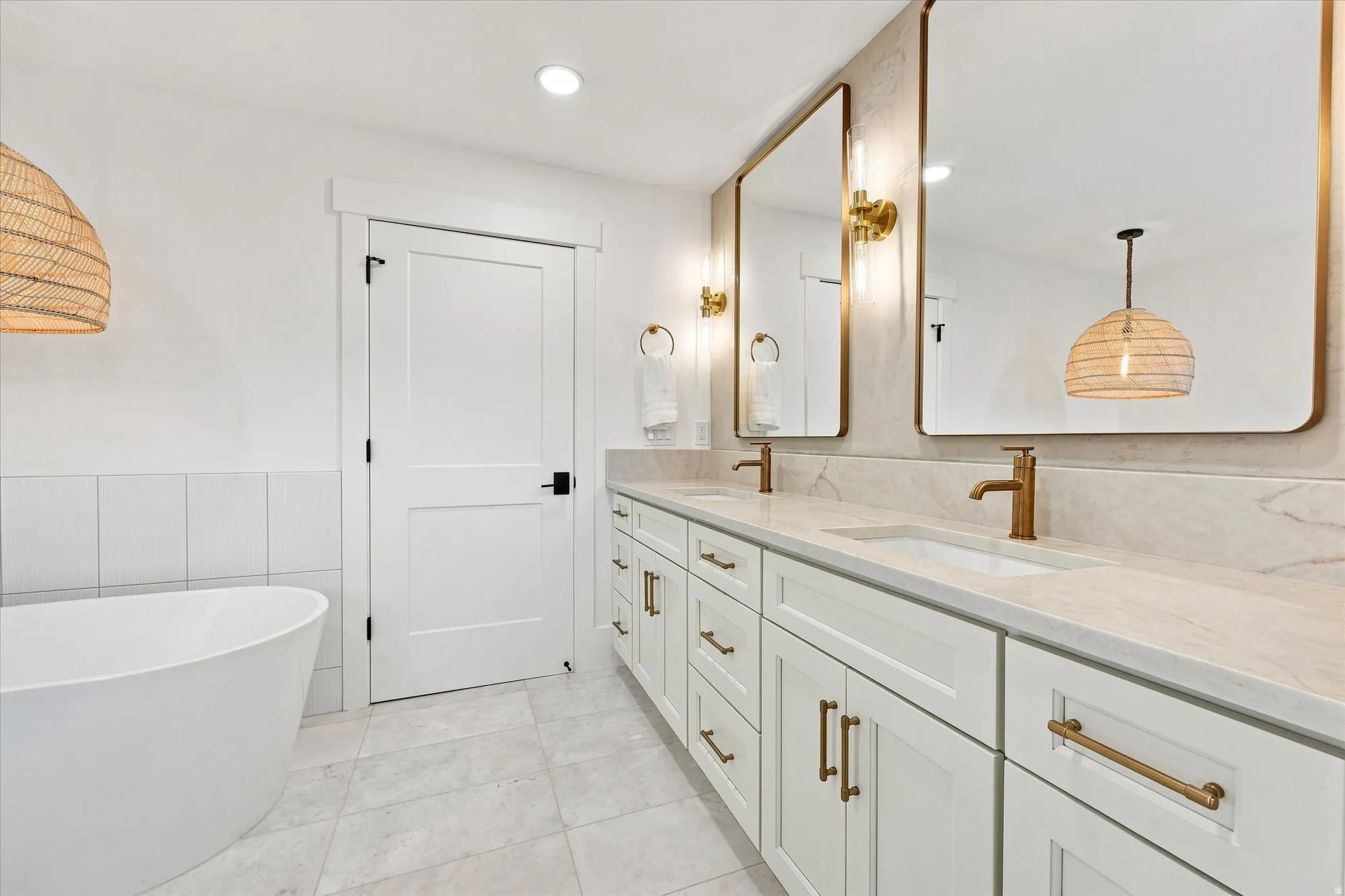 Dual vanity with undermount sinks, stone countertops, and brass-finish hardware