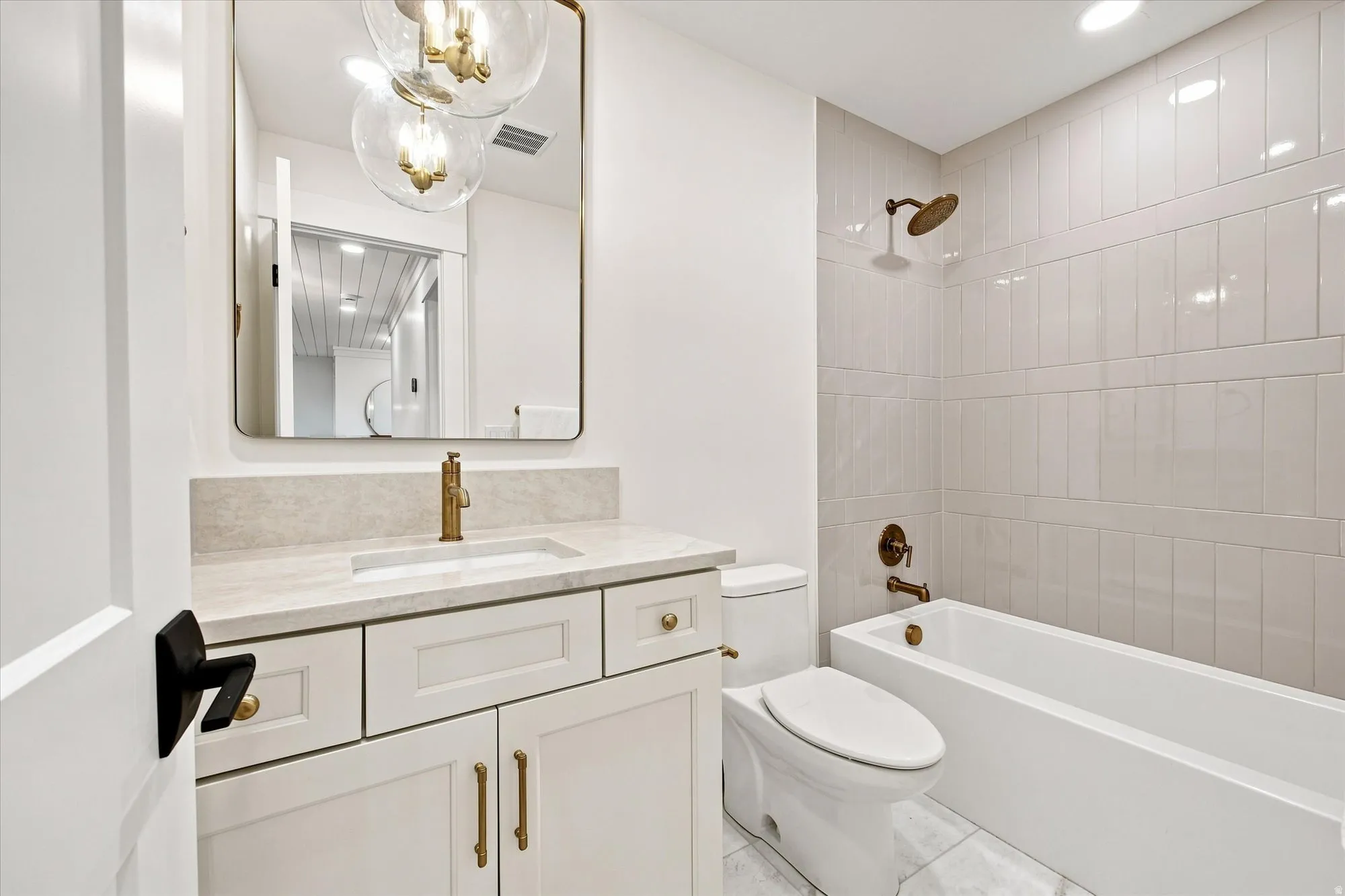 White vanity with gold-finish hardware and a rectangular undermount sink