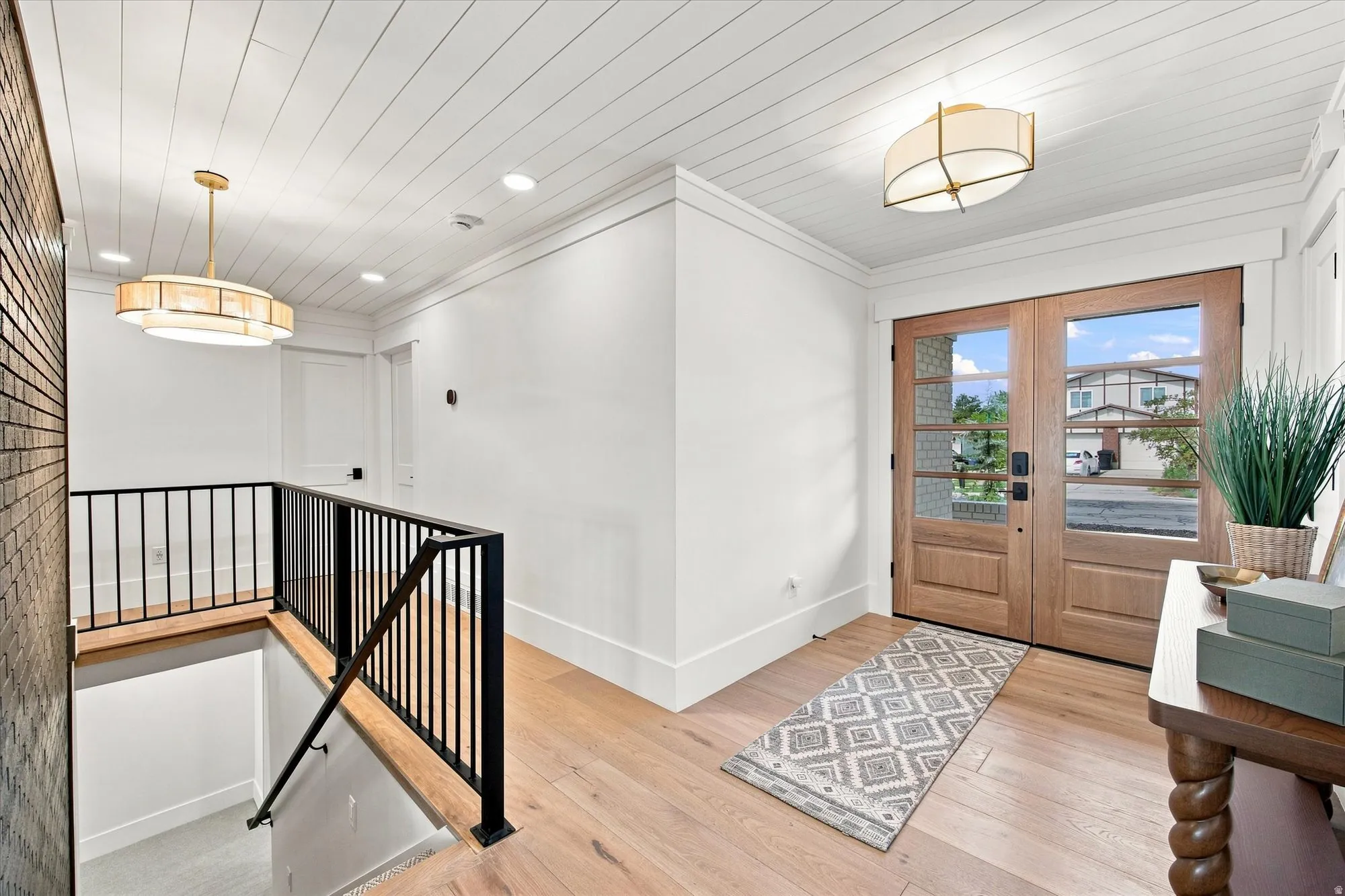 Double-door entry with clear glass panels, wood-finish flooring, shiplap ceiling, and recessed lighting