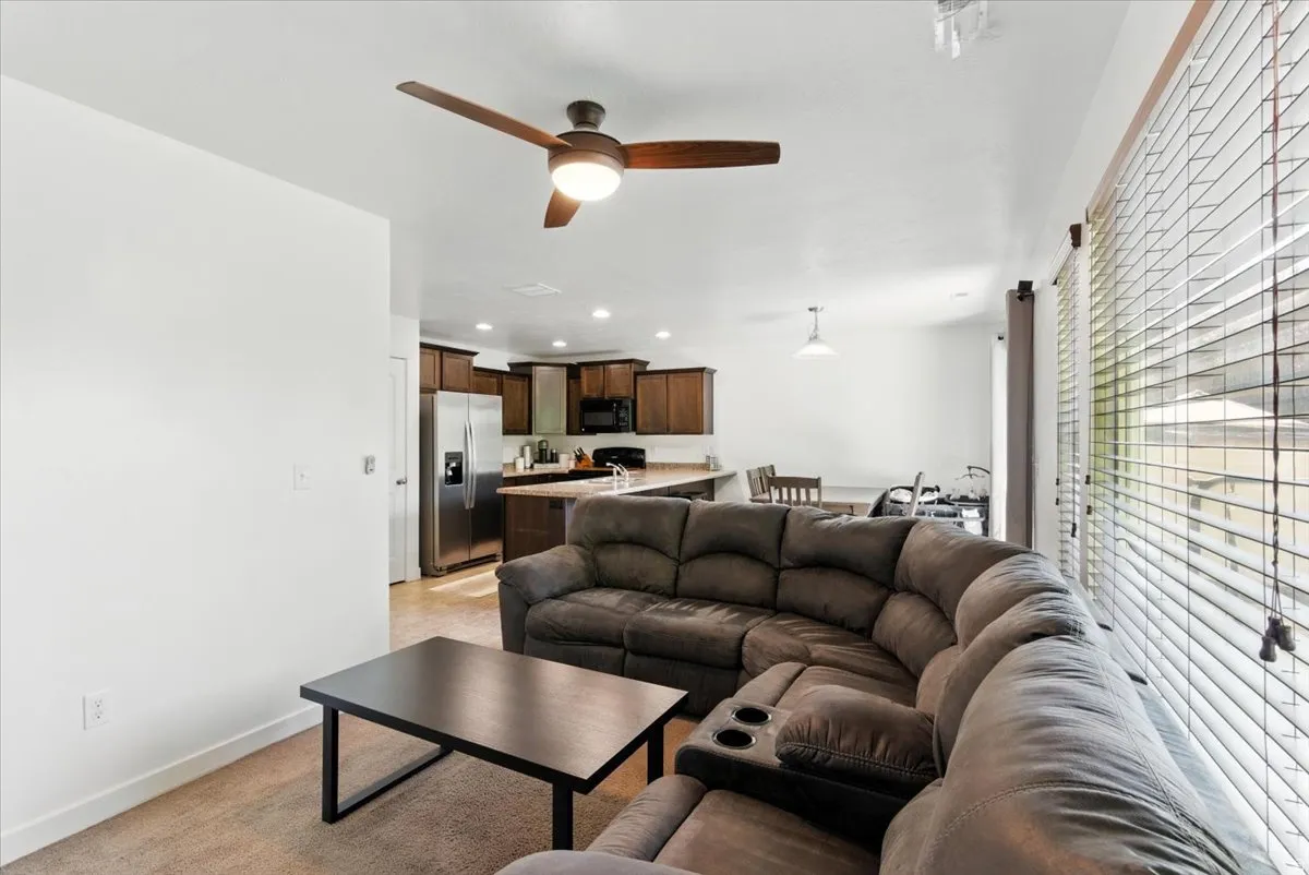 Recessed lighting, wood-finish ceiling fan with integrated lighting, stainless steel refrigerator, stainless steel range hood, built-in cabinetry