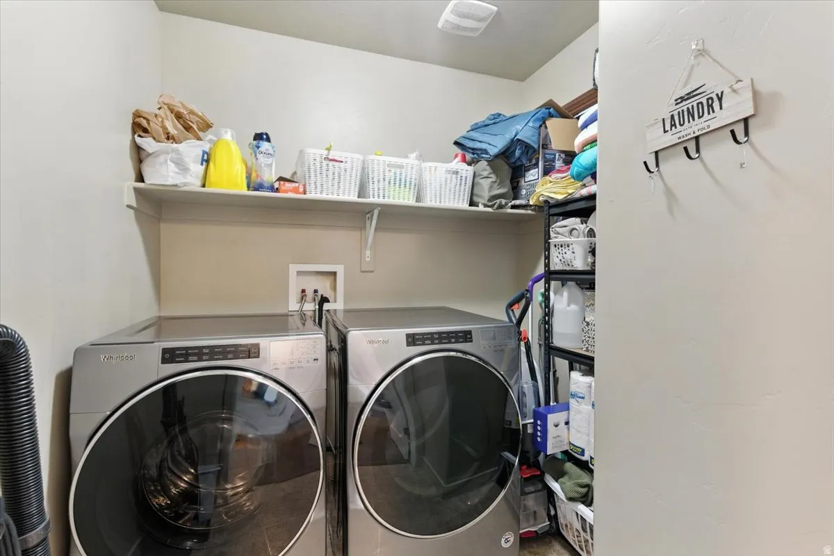 Integrated laundry area featuring appliances and an overhead shelf