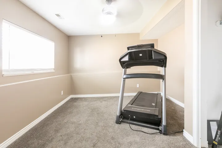 Carpeted room with a ceiling fan, recessed lighting, and a window with blinds