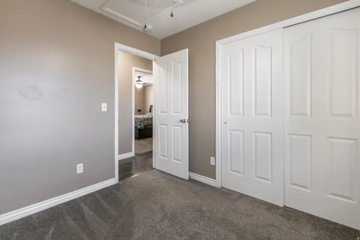 Plush grey carpet, white trim, and a white bi-fold closet door