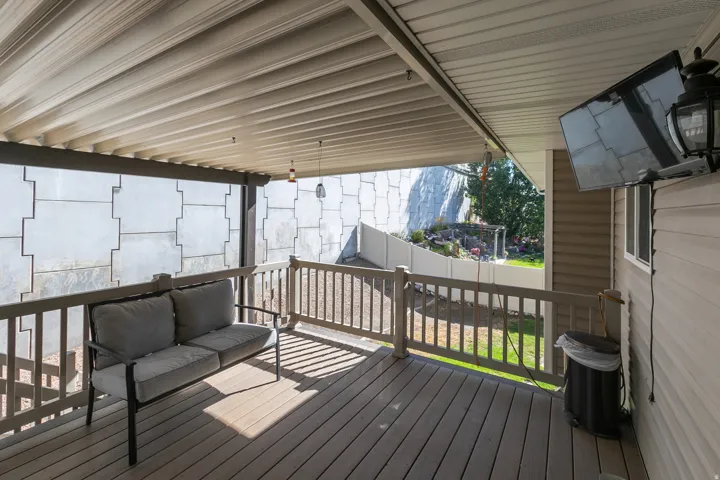 Covered outdoor deck with composite decking and wood-finish railing