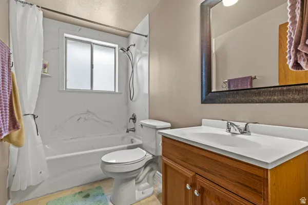 Bathroom with a single vanity, integrated sink, and wood-finish cabinetry