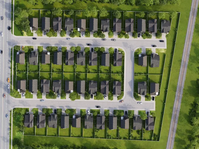 Residential development featuring multiple single-family homes, paved streets, and green spaces