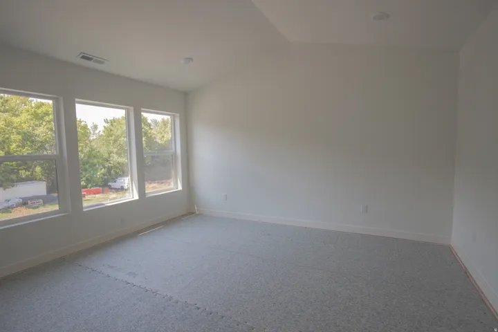 Neutral wall paint, recessed lighting, and triple windows