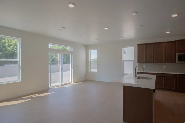 Open concept living space with wood-finish flooring, recessed lighting, and sliding glass doors