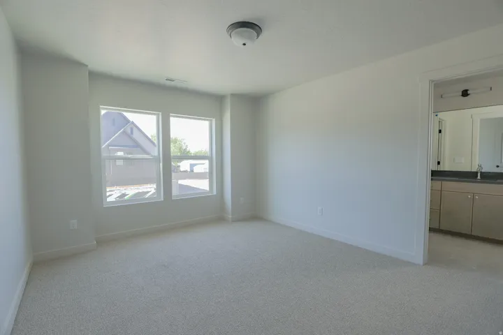 Carpeted room with two large windows and a ceiling-mounted light fixture