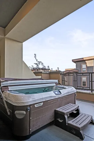 Private patio featuring a built-in spa with cover and steps