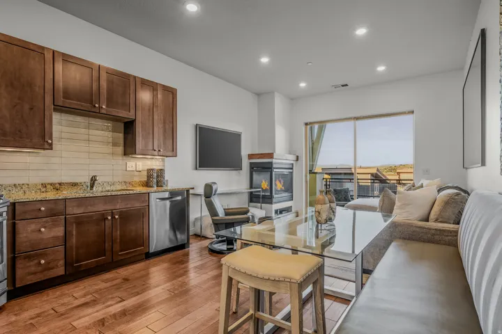 Hardwood-finish flooring throughout, featuring recessed lighting, a modern fireplace, and a sliding glass door