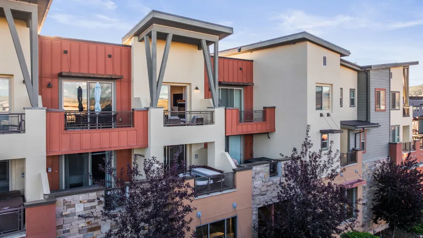 Multi-level exterior with stucco, metal paneling, and stone accents
