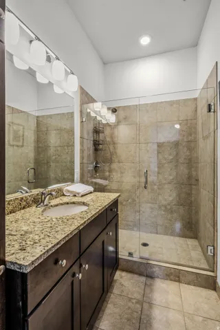 Dark wood-finish vanity with granite countertop and integrated sink