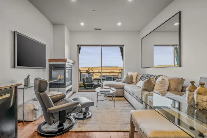 Recessed lighting, wood-finish flooring, and a contemporary fireplace with a wood mantel