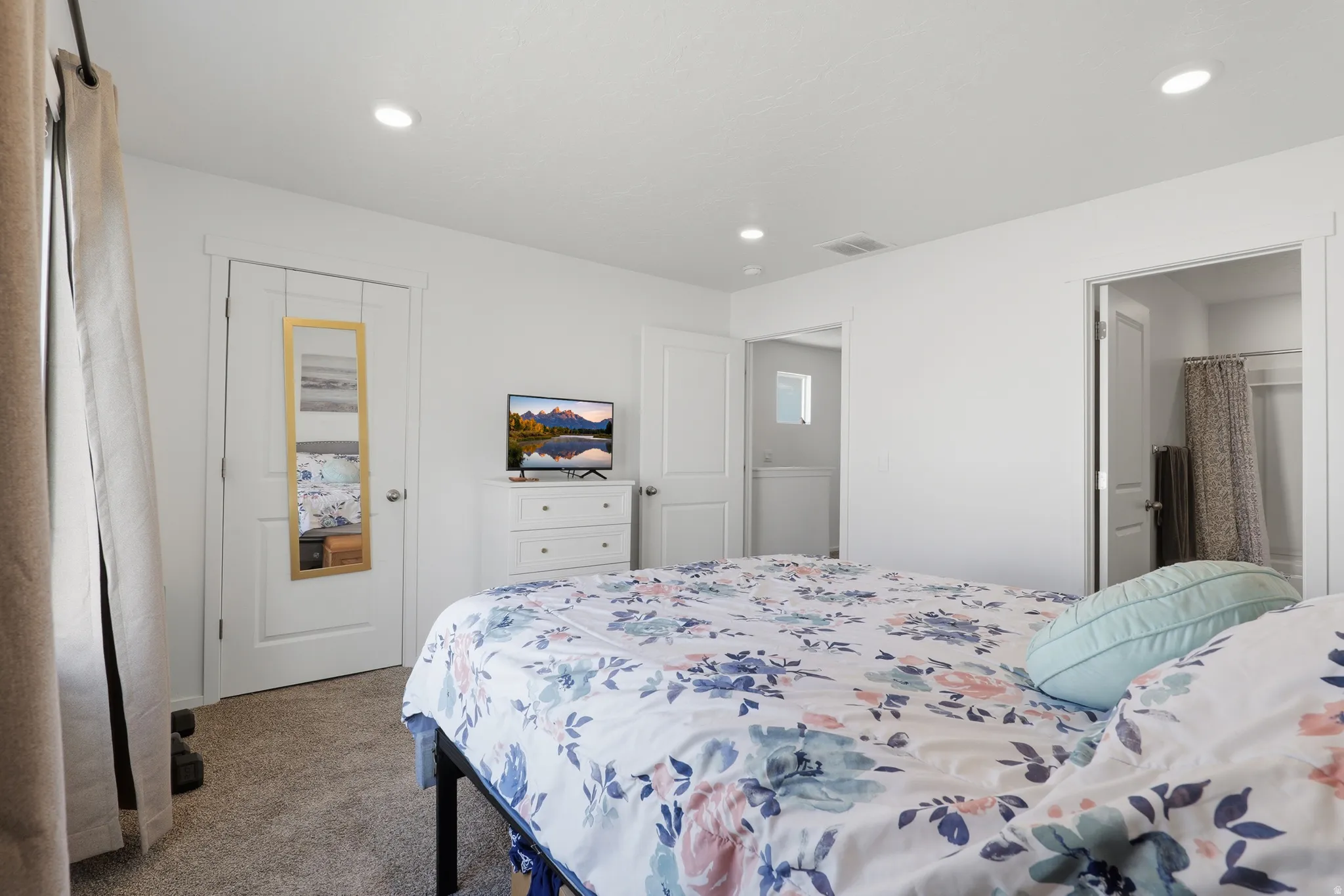 Recessed ceiling lighting, white walls, carpet flooring, a white door, and an additional room entry
