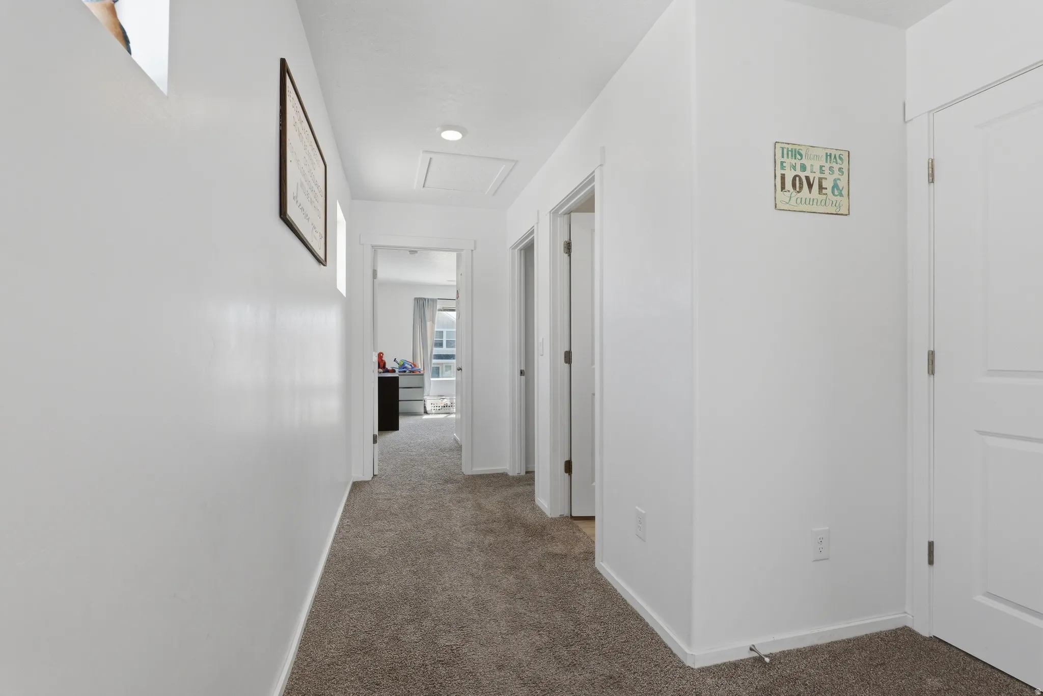 Hallway with neutral carpet flooring and white walls