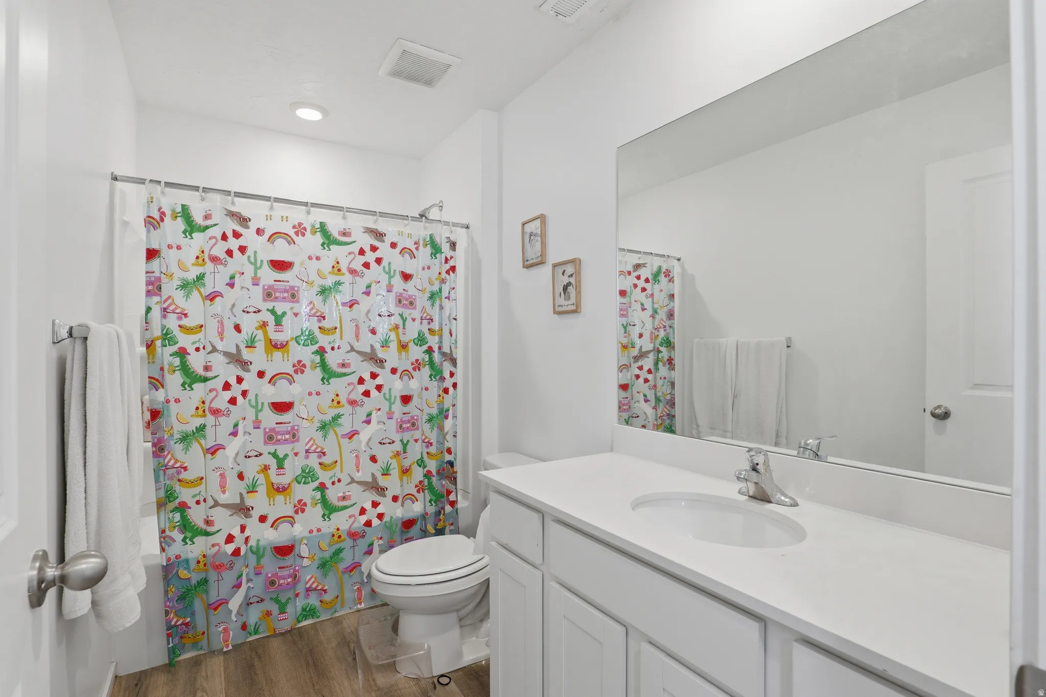 White vanity with integrated sink, chrome faucet, and expansive wall-mounted mirror