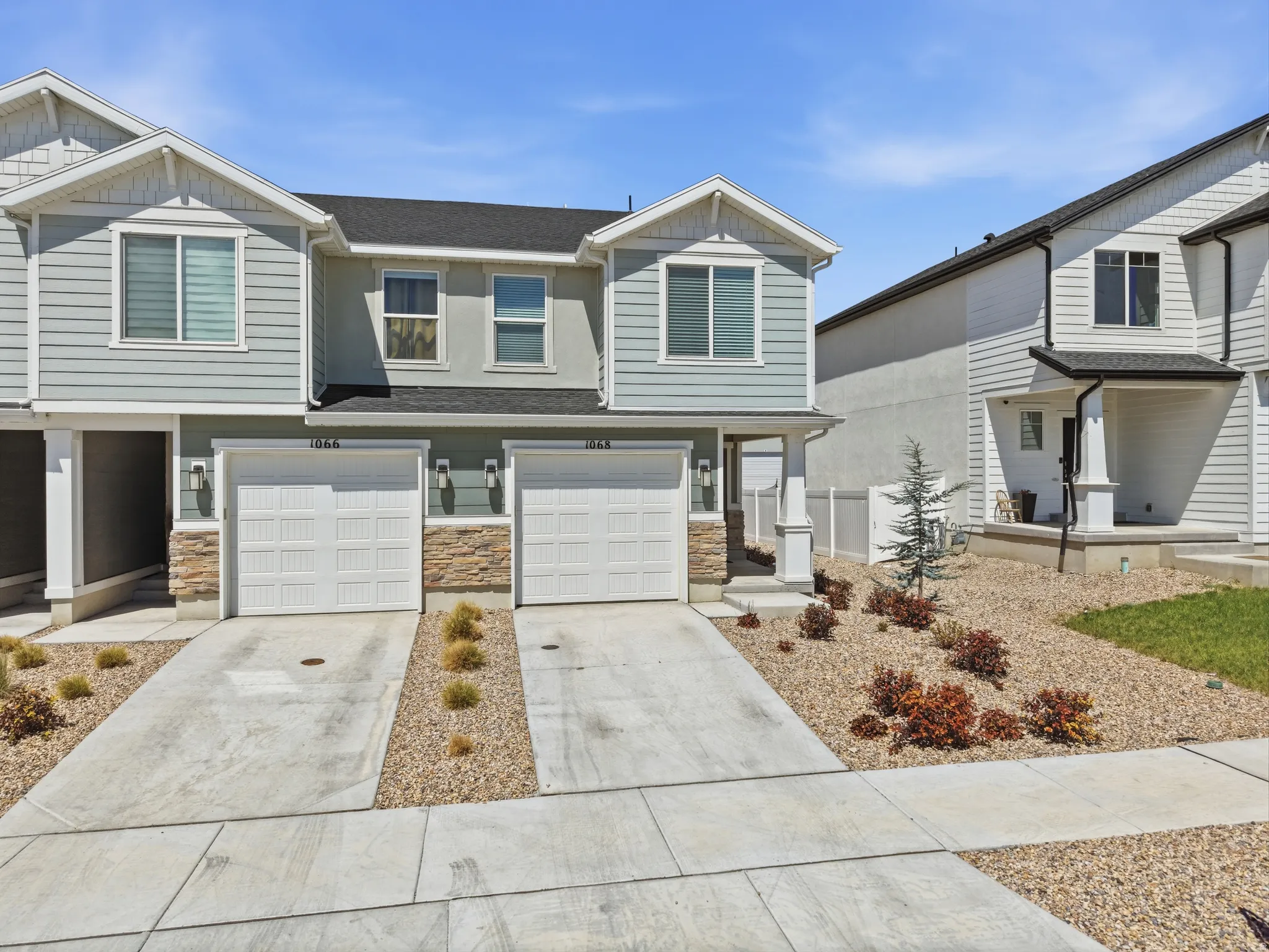 Two-story townhome with siding exterior and stone veneer accents