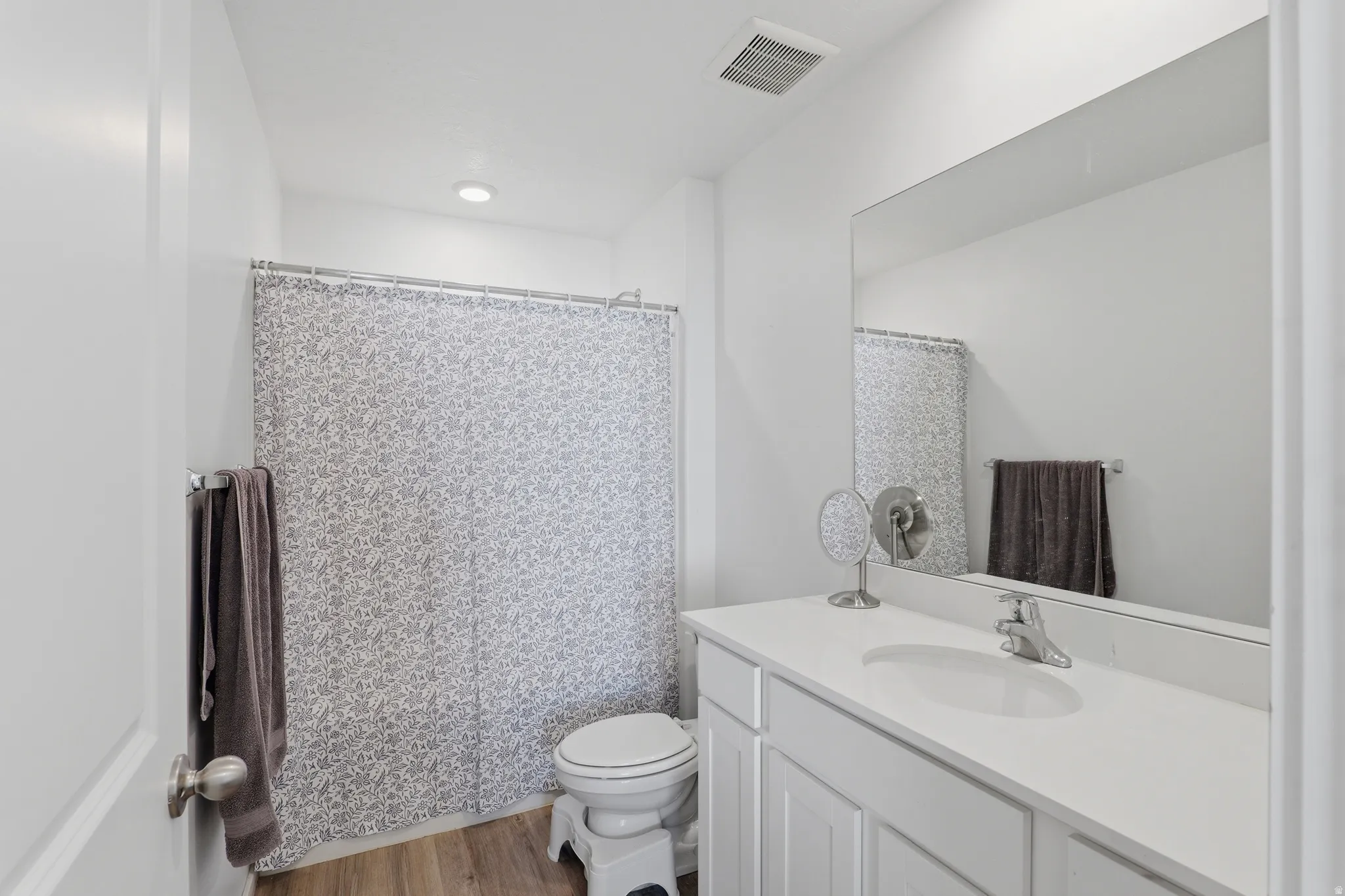 Vanity with an integrated sink, polished chrome faucet, and a large mirror
