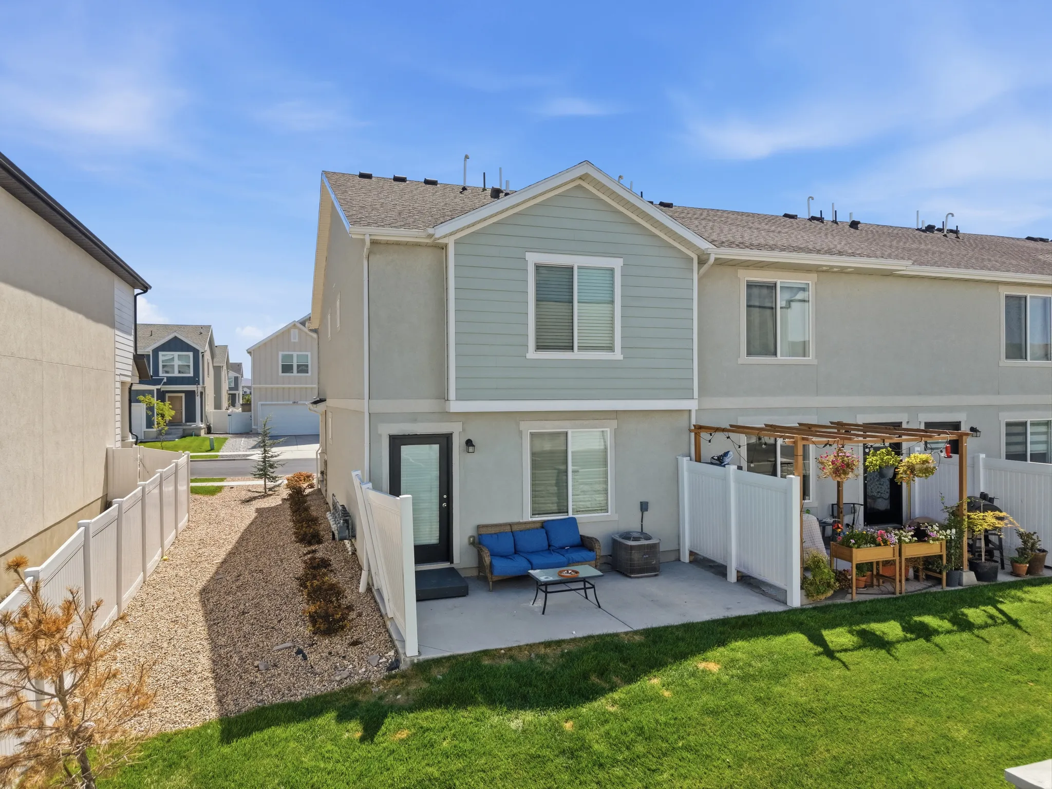Rear exterior featuring a concrete patio, a wooden pergola, and a private fenced yard with a manicured lawn
