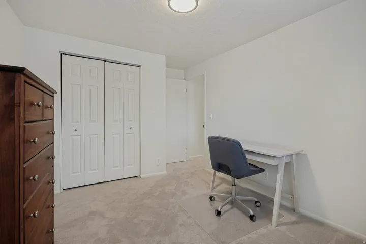 Recessed ceiling lighting, light-colored carpeting, and white walls