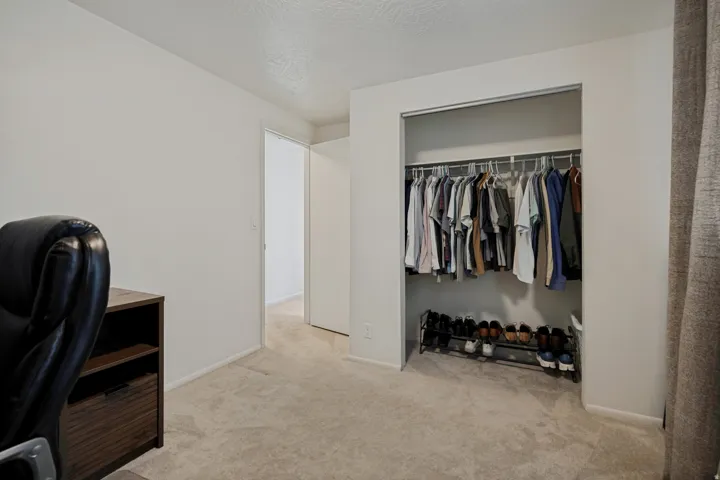 Recessed closet with a metal hanging rod and shelving system