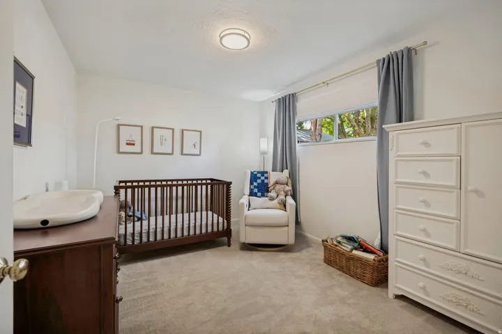 Plush carpeting, a lower horizontal window, and a built-in flush-mount ceiling light fixture