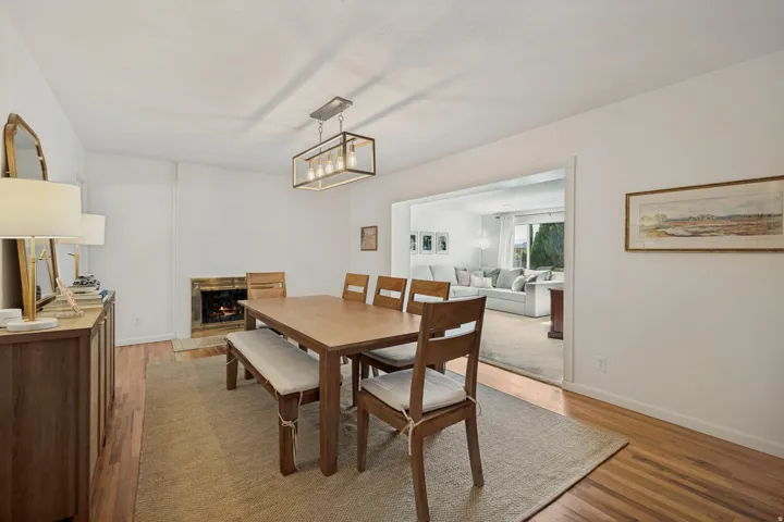 Hardwood flooring, fireplace, recessed lighting, and a modern rectangular chandelier